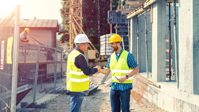 two construction workers shaking hands
