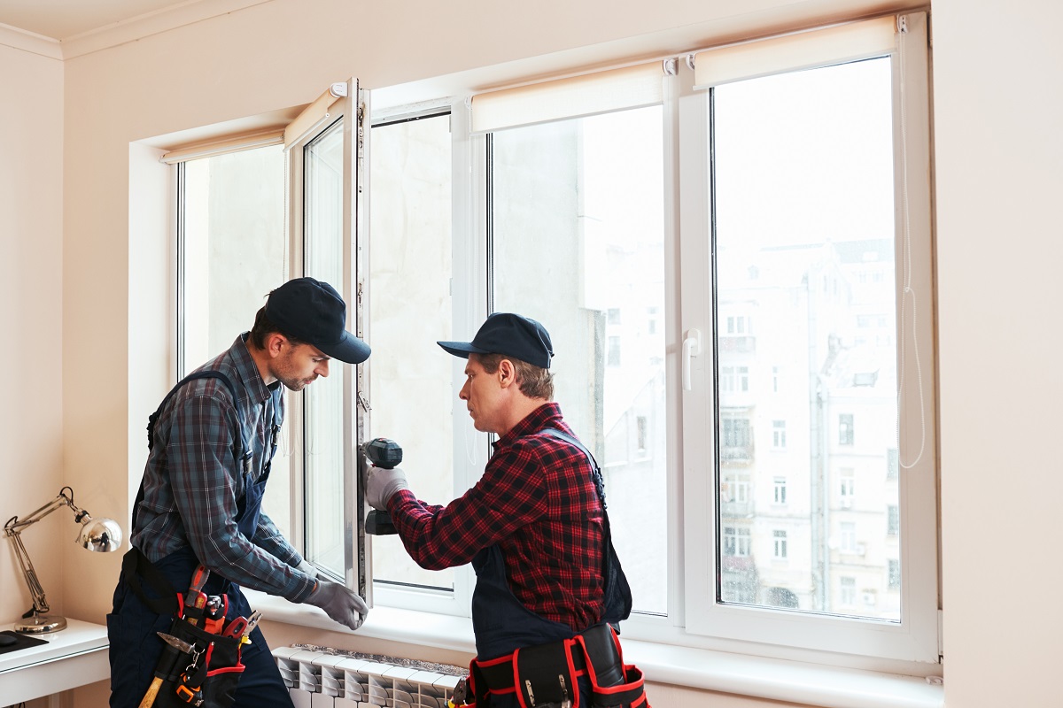 Two glazing installers installing window